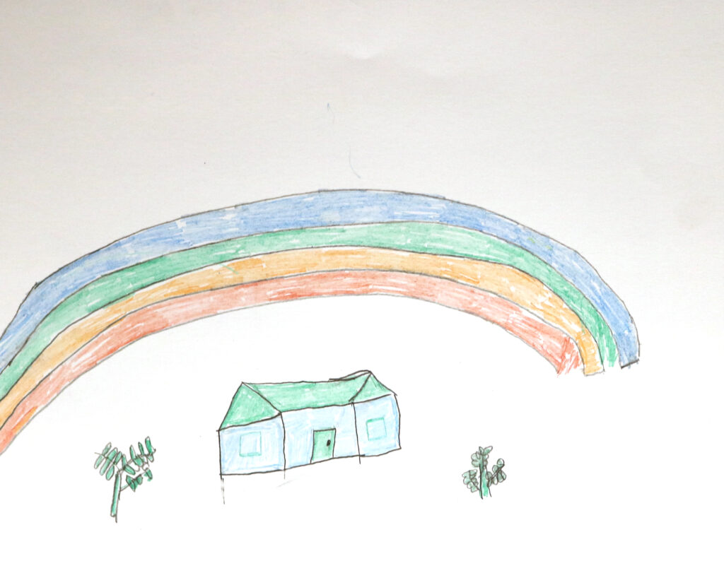 a house beneath a large rainbow